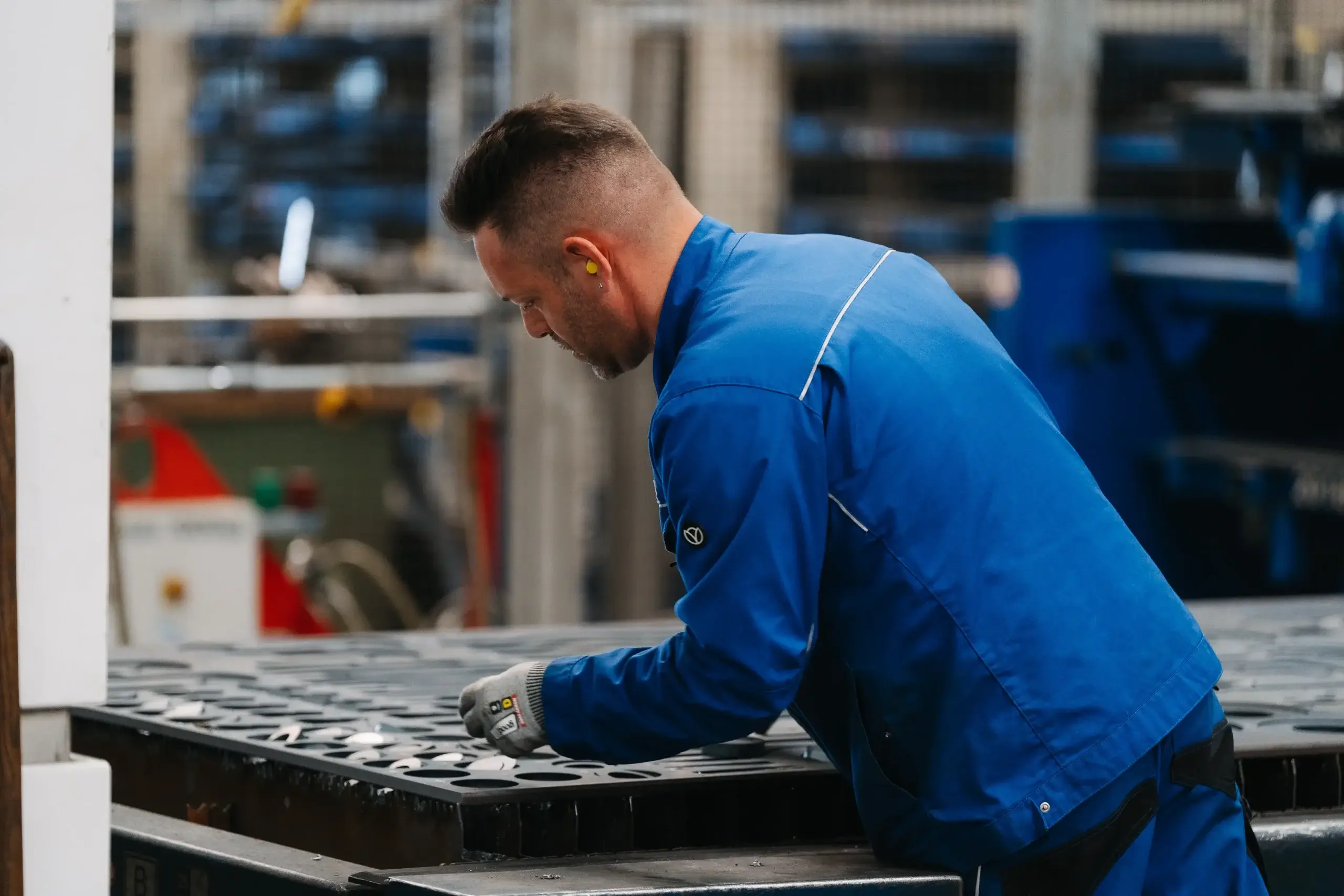 Mitarbeiter sortiert Blechteile