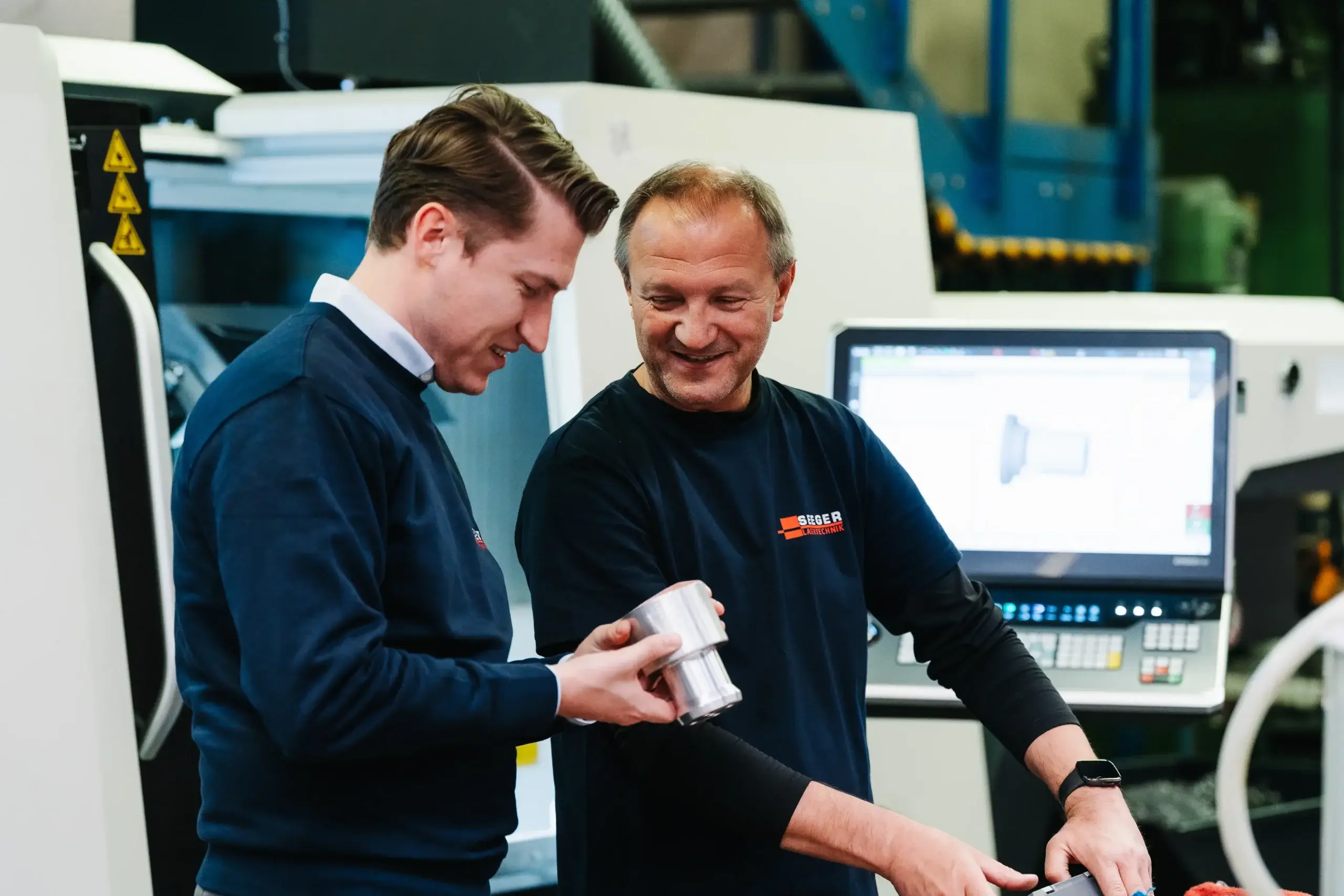 Mitarbeiter begutachten Metallzylinder