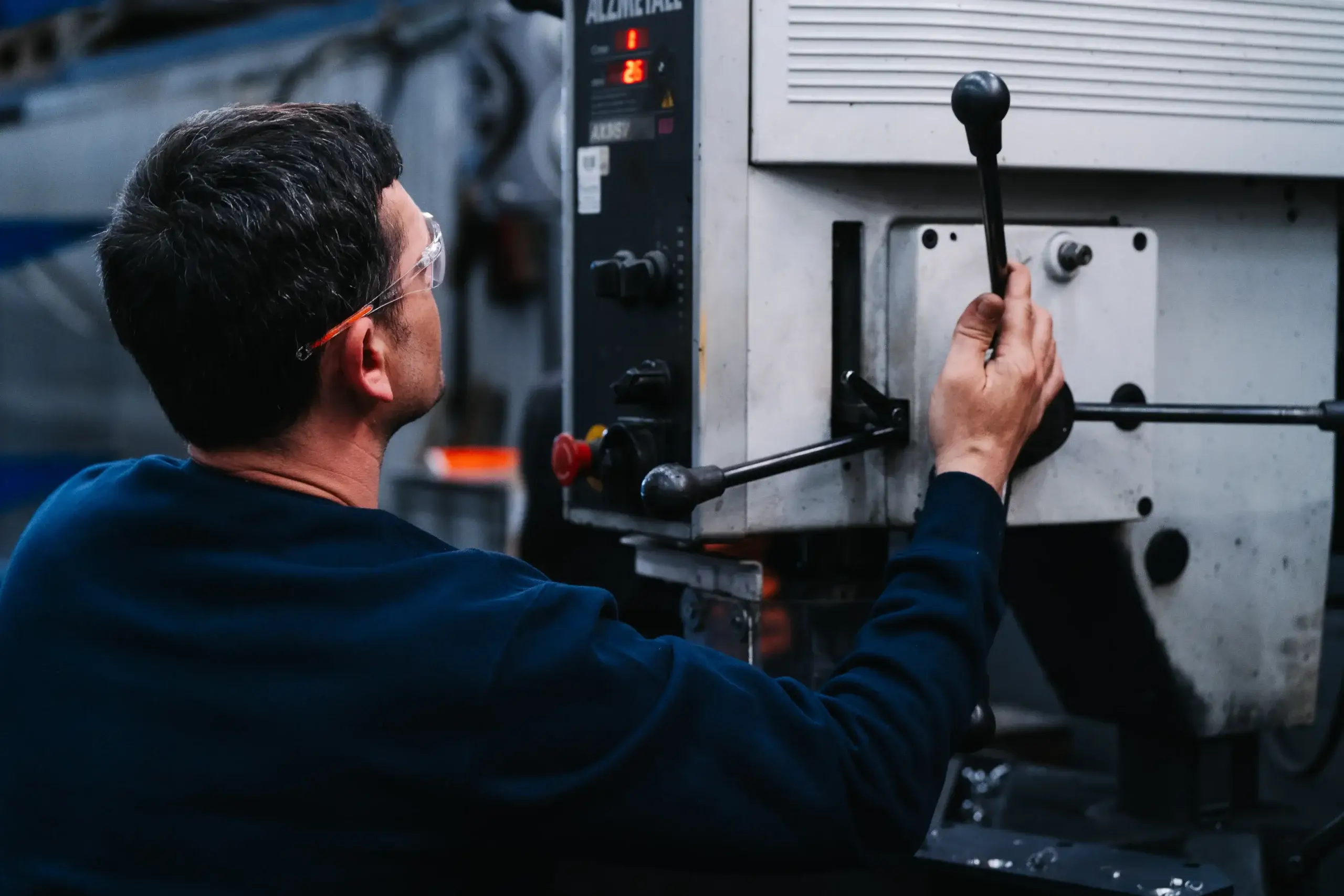 Mann arbeitet an einer industriellen Maschine